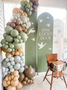 balloons are stacked on top of each other in front of a sign that says one lucky duck