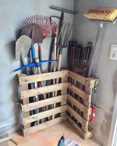 a wooden crate filled with gardening tools on top of a floor next to a wall