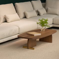 a living room with a couch, coffee table and books on the floor in front of it