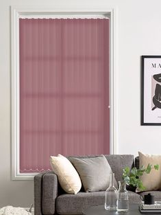 a living room with a couch, coffee table and pink blinds