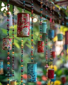 many colorful beads hanging from a wooden beam in front of green plants and trees with lights behind them