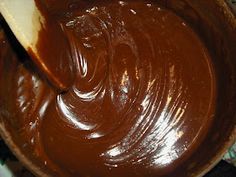 a wooden bowl filled with melted chocolate on top of a table