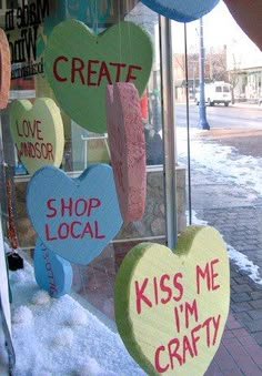 several hearts hanging from the side of a store window