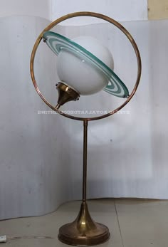 an antique globe on a metal stand with a white ball and green stripe around it