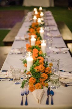 a long table with candles and flowers on it