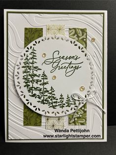 a handmade christmas card with trees and snowflakes on the bottom, which reads seasons greeting