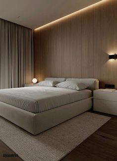 a large bed sitting in the middle of a bedroom next to a wall mounted lamp