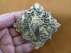 (Internal #B-OTHER-14-4)  This is a beautiful pin/pendant (glued on the back) made of a piece of brass of a Woman “Justice is Blind” on a piece of ornate scrolled repro Victorian backing with filigree design, 2-1/4” wide and 2-1/4" tall.  This gorgeous reproduction Victorian stamped brass is antiqued, then buffed to create some shine. WE SHIP WORLDWIDE! Other accepted payment: Credit card (Mastercard/Visa/Discover) inquire for details. Edible Cupcakes, Justice Is Blind, Blind Design, Green Brooch, Blinds Design, Brass Pin, Wire Pendant, Pin Pendant, Scroll Design