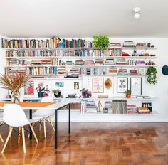 a room filled with lots of bookshelves next to a dining table and chairs