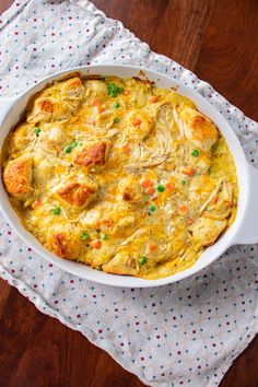 a casserole dish with meat and vegetables in it on a napkin next to a fork