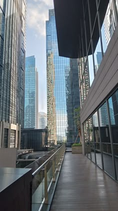 an empty walkway in front of some very tall buildings