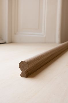 a piece of wood sitting on top of a wooden floor next to a white door