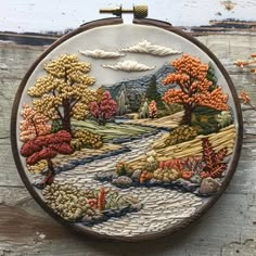 a hand embroidered wall hanging with autumn trees