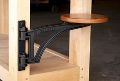 a close up of a wooden shelf with a black iron bracket on it's side