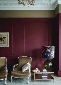 two chairs and a table in a room with purple walls