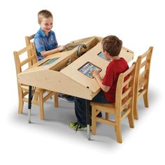 two young boys sitting at a table with an ipad in the shape of a boat