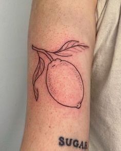 a person with a tattoo on their arm that says sugar and has a lemon on it