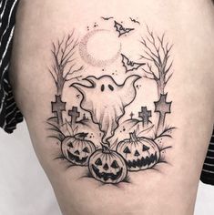 a woman's thigh with halloween tattoos on it