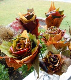 a vase filled with lots of flowers sitting on top of a window sill next to a grass covered field