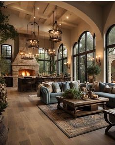 a living room filled with lots of furniture next to large windows and a fire place