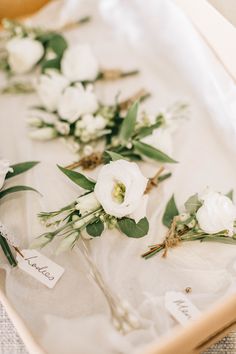 white flowers and greenery are laid out on a tray