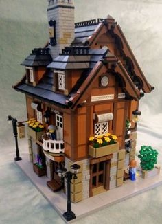 a toy house made out of legos with a clock tower on the top of it