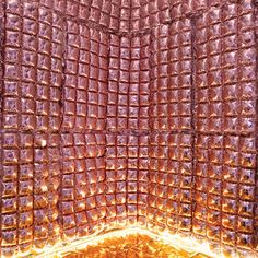 the inside of an oven that is covered in gold foil and lit up with lights