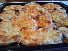 a pan filled with cheese covered food on top of a stove