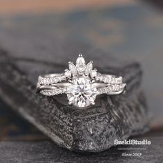 a close up of a diamond ring on a rock