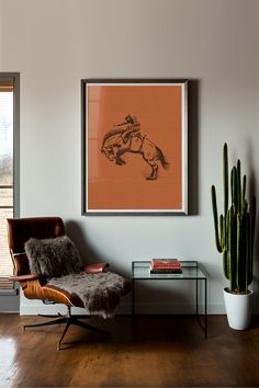 Framed orange poster of a cowboy riding bucking bronco hanging in a modern southwester home living room. Bucking Bronco