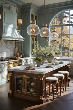 an elegant kitchen with marble counter tops and gold trimmings, surrounded by large windows