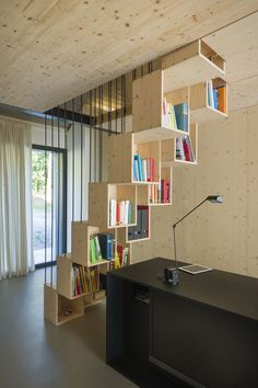 a room with bookshelves and a desk in front of a sliding glass door