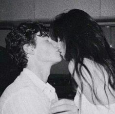 two people are kissing each other in black and white