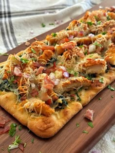 a wooden cutting board topped with a cheesy pizza