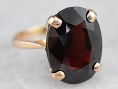 This ring features a simple and classically designed mounting, the structural openwork shoulders lend a sense of light and grace to the mounting. Cut into a classic oval cut, the deep red cherry garnet in the center adds a lovely pop of color and also an interesting shape to a simple ring!Metal: 14K Yellow GoldGem: Garnet 14.25 CaratsGem Measurements: 16.2 x 11.9 mm, OvalRing Size: 7.25 Simple Ring, Red Cherry, Ring Metal, Rings Simple, Cocktail Ring, Cocktail Rings, Metal Rings, Deep Red, The Deep