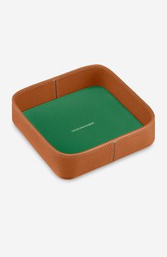 a brown leather tray with green interior