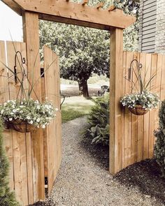 two wooden gates with flower pots on them