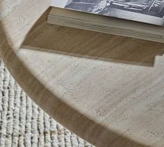 an open book sitting on top of a wooden table next to a white rug with a black and white photo