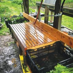 a wooden bench sitting on top of a lush green field next to a pile of dirt