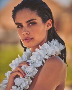 a beautiful woman wearing white flowers around her neck