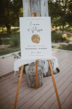 a sign that is on top of a wooden easel in front of a tree