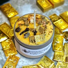 a cup filled with yellow liquid surrounded by gold bars and other golden foiled objects