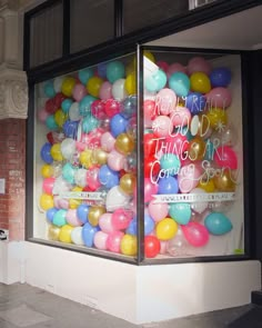 a store front with balloons in the window