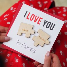 a person holding a card with two pieces of puzzle on it that says i love you to pieces