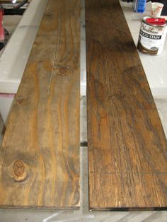 two pieces of wood sitting on top of a counter next to paint and other items