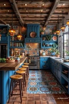 a kitchen with blue cabinets and wooden floors, an island countertop and stools