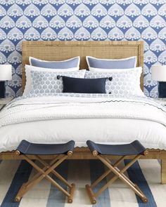 a bed with blue and white wallpaper in the background