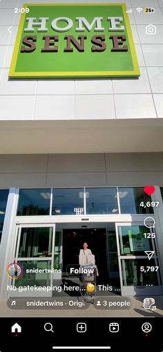 the front of a building with a man standing in the doorway and looking at his cell phone