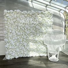 a white chair sitting in front of a flower covered wall