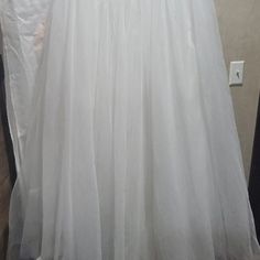 a white wedding dress hanging on a hanger